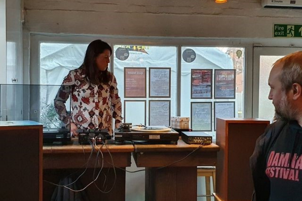 Lisa standing over the decks at the brewery's vinyl night